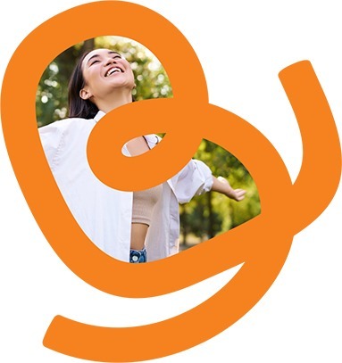 Imagem da letra "B" de Biovita preenchida com a foto de uma mulher sorrindo com os braços abertos e olhando para o céu. A imagem transmite uma sensação de liberdade, alegria e conexão com a natureza, reforçando os valores de bem-estar e positividade associados à marca Biovita.